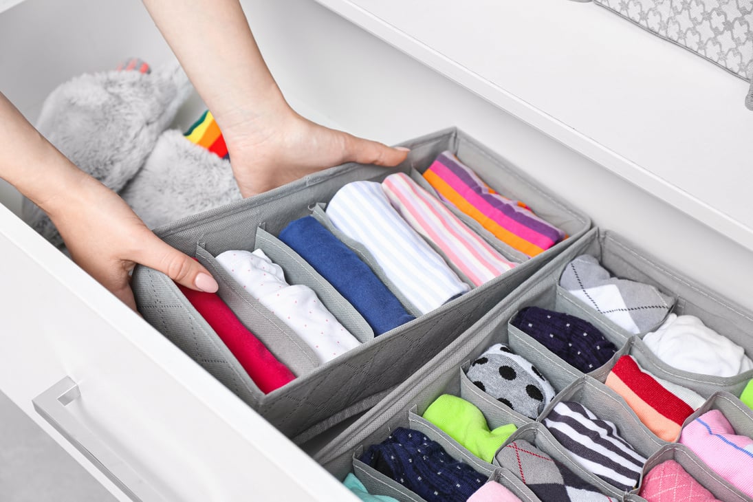 Woman with Clean Clothes in Organizers at Home